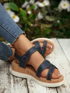 Macro view of women's navy blue wedge platform sandals featuring a stylish wood grain midsole