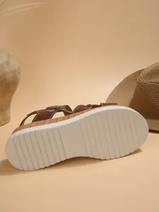 Detail view of the non-slip white sole on brown wedge platform sandals for women