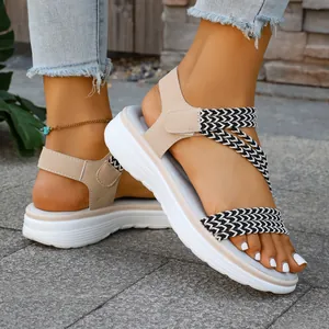 Detailansicht beige Damen-Flachsandalen mit schwarz-weiß geflochtenen Riemen