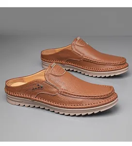 Close-up view of brown pebble-grain leather mules featuring durable non-slip jagged soles