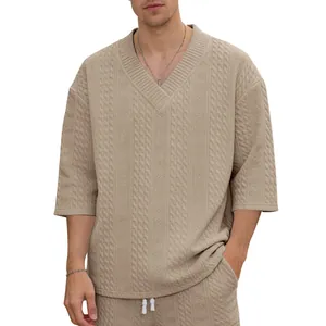 Nahaufnahme des feinen Zopfstrickmusters dieses beigen Oversize-Strickoberteils für Herren
