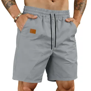 Close-up of men's quick-dry grey beach shorts with drawstring and leather patch