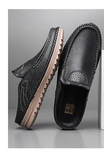 Detailed view of men's black pebbled leather mules with durable tan slip-resistant soles.