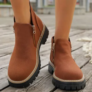 Vista detallada de botines de gamuza marrón para mujer con cremallera lateral dorada.