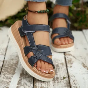 Stylish navy blue wedge sandals for women featuring white stitching and wood-grain soles.