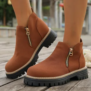 Primer plano de botines de ante marrón para mujer con cremallera lateral de moda
