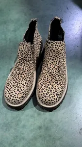 Primer plano de botines de leopardo modernos para mujer con cremallera lateral y suela de tracción