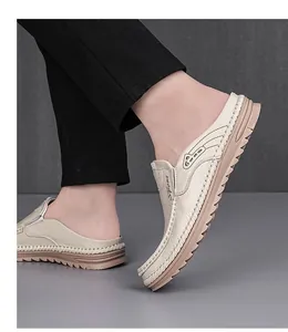 Detail view of men's beige leather mules with a textured finish and soft thick sole