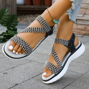Nahaufnahme von stilvollen flachen Sandalen mit geflochtenen Riemen für den Sommer