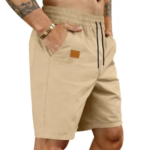 Detail view of khaki quick-dry men's casual beach shorts with elastic waist and patch