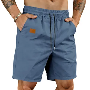 Detail view of men's quick-dry blue beach shorts with drawstring waist and pocket patch