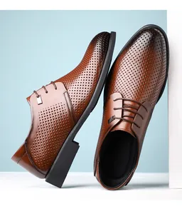 Primo piano di scarpe eleganti da uomo in pelle traforata marrone per abbigliamento