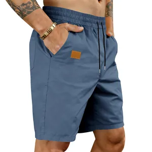 Close-up detail of men's quick-drying blue beach shorts showing the drawstring waist and fit.