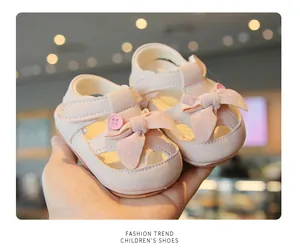 Detail view of soft pink baby girl sandals with cute decorative bows and closed toe