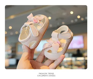 Close-up of pink baby girl sandals with soft fabric bow and protective closed-toe design.
