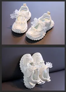 Detailed close-up of girls' white mesh sandals featuring elegant pearls and ribbon bows