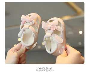Detailed close-up view of pink baby girl sandals featuring a cute bow and button decoration