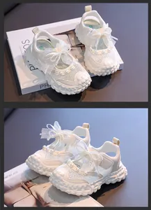 Close-up of white girl's princess sandals with mesh design and pearl bow decoration