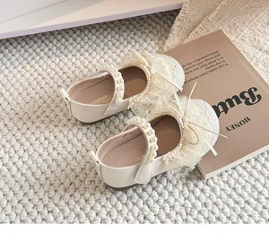 Mary Janes crème pour filles avec nœud en dentelle et détails de bride en perles.