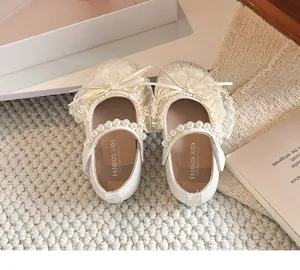 Vue détaillée de chaussures de princesse pour fille avec nœud en dentelle et perles.