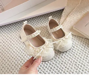 Détail de chaussures princesse crème pour filles avec bride perle et nœud dentelle