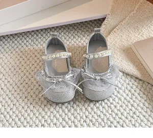 Détail en gros plan de chaussures de princesse argentées pour bébé avec perles et dentelle