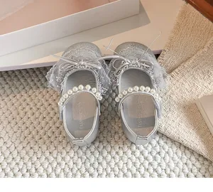 Vue de dessus de chaussures de princesse argentées pour filles avec perles et nœud en dentelle