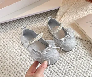 Gros plan sur les chaussures de princesse argentées à paillettes avec perles et dentelle