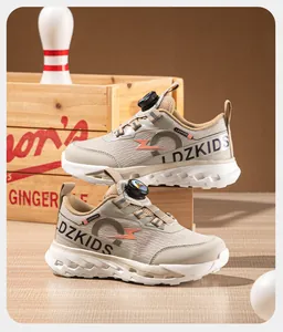 Chaussures de sport beiges pour enfants avec système de laçage à cadran rotatif.