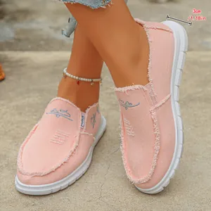Detail view of pink canvas slip-on loafers with frayed edges and 3cm thick sole.