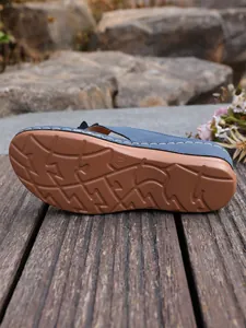 Detail van de antislip rubberen zool van een blauwe teenslippers met sleehak voor dames