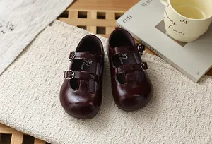 Primer plano de zapatos Mary Jane granates para niña con correa en T y estilo retro