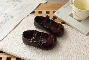 Detalle de zapatos Mary Jane de cuero burdeos para niñas con correas de hebilla