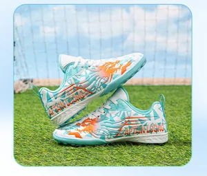 Detail view of children's turf soccer shoes with colorful dragon and geometric patterns