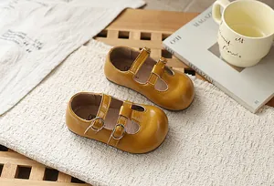 Zapatos amarillos de estilo francés con tira en T para niña en un ambiente acogedor.