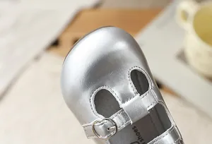 Primer plano detallado de zapato Mary Jane plateado para niña con hebilla metal
