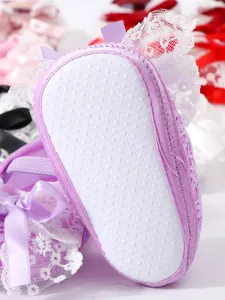 Close-up of purple lace newborn shoe with non-slip soft sole for baby girls