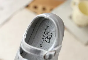 Primer plano de zapato Mary Jane plateado para niña con detalle de hebilla y suela.