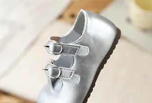 Primer plano detallado de zapatos de princesa Mary Jane plateados para niña con hebillas