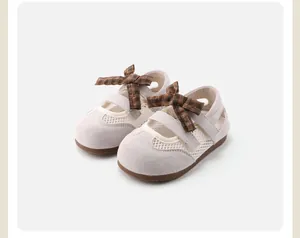 Detail view of grey children's sandals with mesh panels and a brown plaid bow decoration