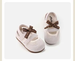 Detailed view of beige toddler girls' shoes with brown plaid bow and mesh panels.