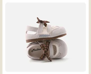 Close-up of girls' grey closed-toe sandals with plaid bow detail and soft rubber sole