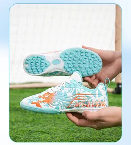 Close-up of children's TF soccer shoes with dragon print and non-slip sole