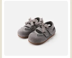Close-up of girls' gray princess shoes featuring a mesh design and a plaid bow