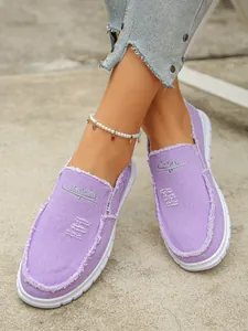 Close-up of stylish purple canvas slip-on loafers for women with unique distressed raw edges