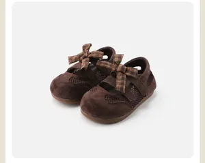 Detail view of brown children's closed-toe sandals with plaid bow decoration