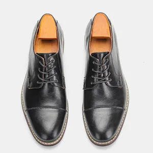 Top-down detail of classic black men's formal leather shoes with wooden shoe trees.