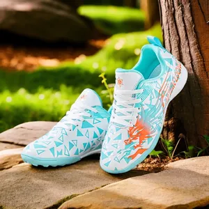 Children's turf soccer shoes featuring orange dragon and blue geometric patterns