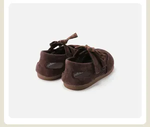 Close-up detail view of brown toddler girl sandals featuring plaid bow and mesh panels