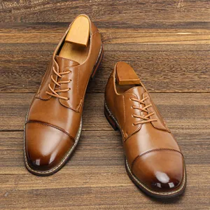 Detailed macro view of polished brown leather dress shoes featuring elegant cap toe design.